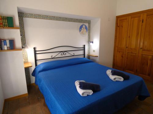 a bedroom with a blue bed with towels on it at Scappo in Umbria, Casale Piccino in Collicello