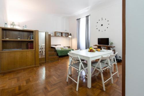 eine Küche und ein Wohnzimmer mit einem weißen Tisch und Stühlen in der Unterkunft Vatican Apartment Borgo Pio in Rom