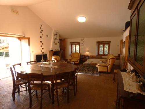 a living room with a wooden table and chairs at Scappo in Umbria, Casale Piccino in Collicello
