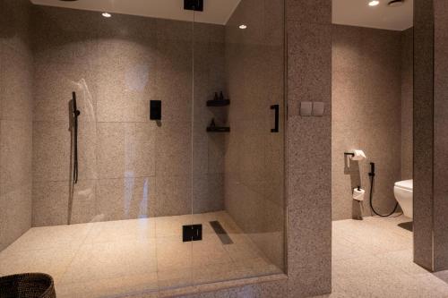 a bathroom with a shower with a glass door at Mantis Akagera Game Lodge in Akagera
