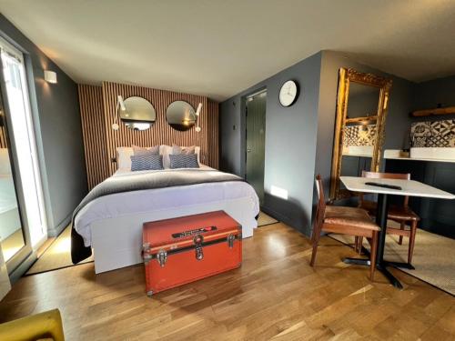 a bedroom with a bed with a red suitcase at Rockmount Rooms & Apartment in Tavistock