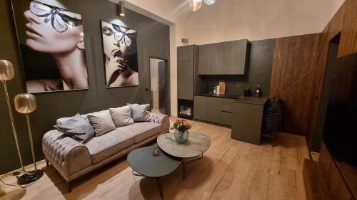 a living room with a couch and a table at TRESOR Delux Apartment in Osijek