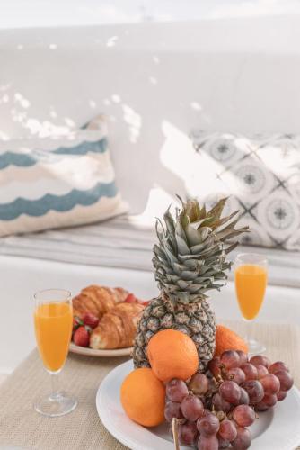 a pineapple on a plate with fruit on a table at Dibellee Mykonos Studios in Glastros