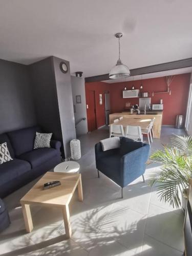 un salon avec un canapé bleu et une table dans l'établissement Millerand maison climatisation 3 chambres jardin et stationnement proche intra muros, à Avignon