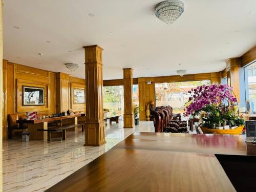 a lobby with a table and chairs and flowers at Khách Sạn Metro Ban Mê in Buon Ma Thuot