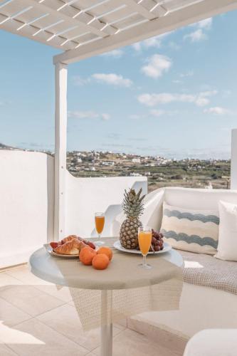 a table with fruit and drinks on a patio at Dibellee Mykonos Studios in Glastros