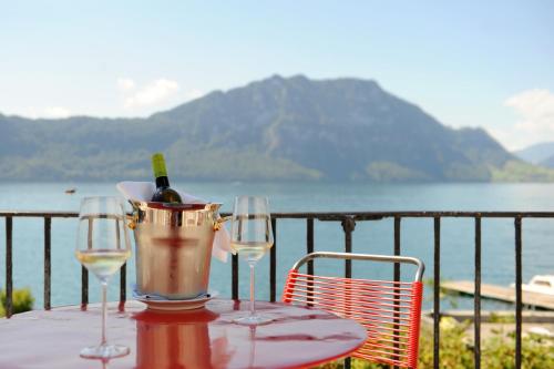 a table with two glasses and a bucket of wine at Seehof Hotel Du Lac in Weggis