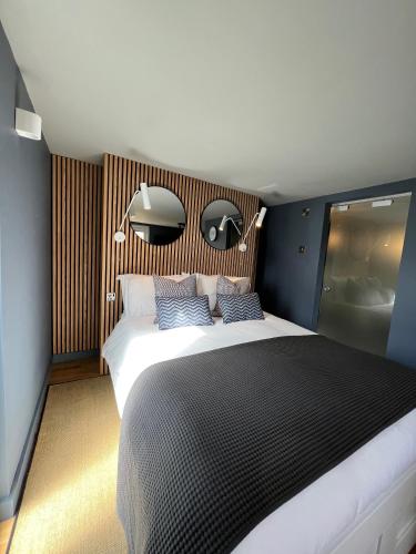 a bedroom with a large bed with two blue pillows at Rockmount Rooms & Apartment in Tavistock
