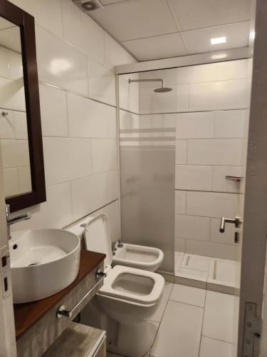 a bathroom with a sink and a toilet and a shower at PH suites in Río Cuarto