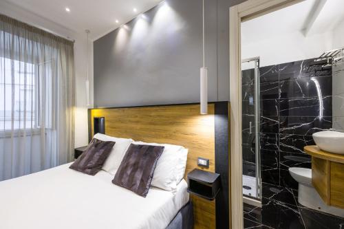 um quarto de hotel com uma cama e uma casa de banho em Hotel Bella Napoli em Nápoles