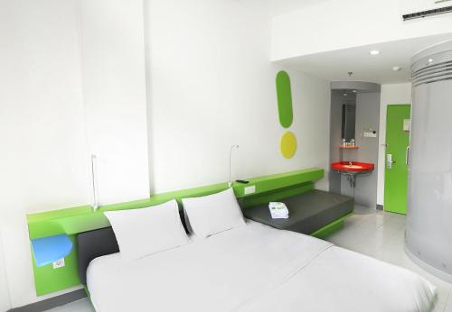 a bedroom with a white bed and a red stool at POP! Hotel Kemang Jakarta in Jakarta
