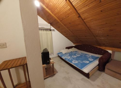 um pequeno quarto com uma cama e uma televisão em Apartman Marija em Tivat