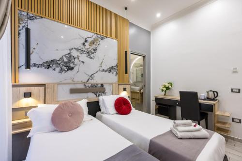 a hotel room with two beds and a desk at Hotel Bella Napoli in Naples