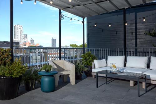 a patio with couches and a table and some plants at One Hundred Shoreditch in London