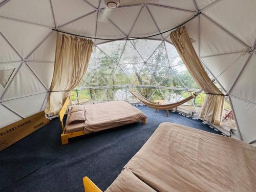 a room with two beds in a dome tent at Tropical eglamping in Tân Phú