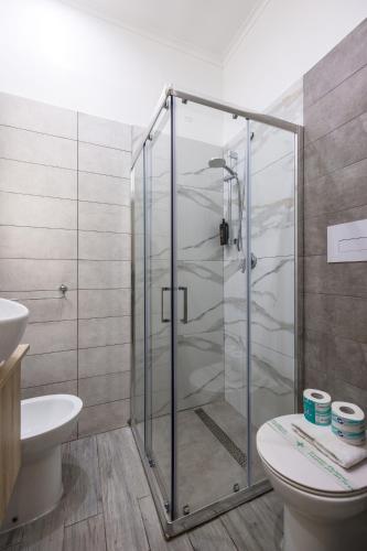 a bathroom with a shower with a toilet and a sink at Hotel Bella Napoli in Naples