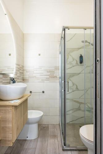 a bathroom with a shower and a toilet and a sink at Hotel Bella Napoli in Naples