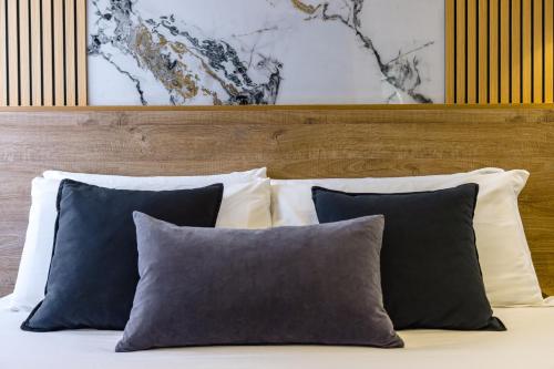 a bed with two pillows and a wooden headboard at Hotel Bella Napoli in Naples