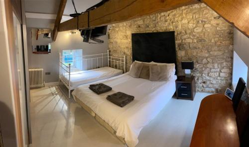 a bedroom with a large bed in a stone wall at Winnie Cottage - Hot Tub, Games Room, Sauna, Large Garden in Stocksfield