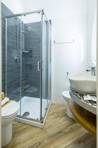 a bathroom with a shower and a toilet and a sink at Hotel Bella Napoli in Naples