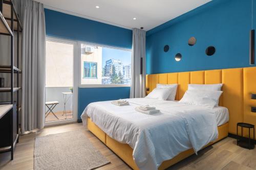 a bedroom with a large bed with a blue wall at UrbanBllok5 in Tirana