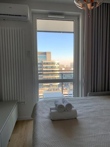 a bedroom with a bed with two rolled towels on it at Warsaw Home Suites in Warsaw