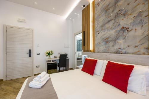 a bedroom with a large white bed with red pillows at Hotel Bella Napoli in Naples