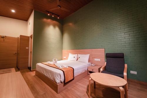 a bedroom with a bed and a chair and a table at Vivera Highlands in Kodaikānāl