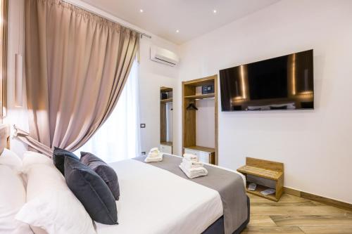 a hotel room with a bed and a flat screen tv at Hotel Bella Napoli in Naples