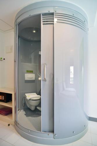 a bathroom with a toilet inside of a glass door at POP! Hotel Kemang Jakarta in Jakarta