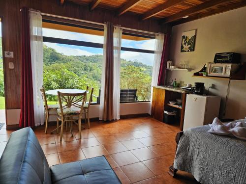 Habitación con cama, mesa y ventana en Apartment Monte Luna Mountain View en Monteverde