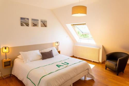 - une chambre avec un lit et une chaise noire dans l'établissement Villa KalonBreizh, Piscine privée chauffée & Sauna, à Plouhinec