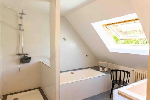 une salle de bain avec une baignoire et une fenêtre dans l'établissement Villa KalonBreizh, Piscine privée chauffée & Sauna, à Plouhinec