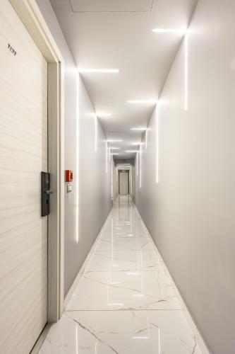 a corridor in a building with white walls and white tile floors at Hotel Bella Napoli in Naples