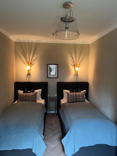 2 camas en una habitación con luces en la pared en Ferienapartment Residenz "Weisses Rössl am See" en Thiersee