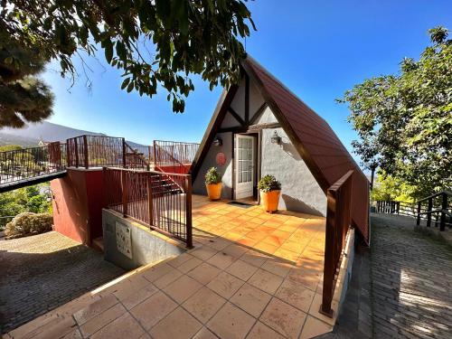 a small house with a triangular roof on a patio at Finca Oscar Burchard in La Orotava