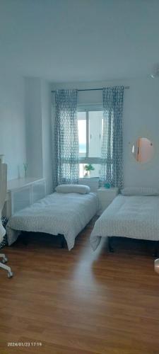 a bedroom with two beds and a window at 1st line sea view 3 rooms apartment in Tenerife 92m2 in Bajamar