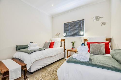 a bedroom with two beds and a couch at Atlantic 62 in Yzerfontein