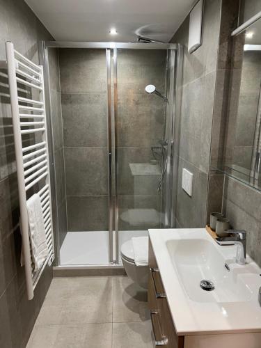 y baño con ducha, aseo y lavamanos. en Ferienapartment Residenz "Weisses Rössl am See" en Thiersee