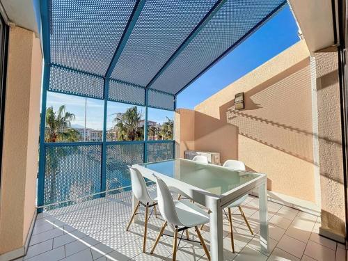 une table blanche et des chaises sur un balcon avec vue dans l'établissement 3227-Appart 4 personnes climatisé donnant sur le Port Argeles, à Argelès-sur-Mer