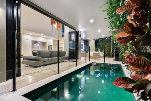 a swimming pool in a house with a living room at Flagstaff Pavillion - A Lush Subtropical Paradise in Port Douglas