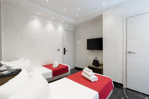 a hotel room with two beds and a flat screen tv at Hotel Bella Napoli in Naples