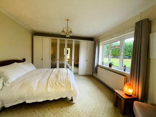 a bedroom with a white bed and a window at Karinya suite in Llanvaches
