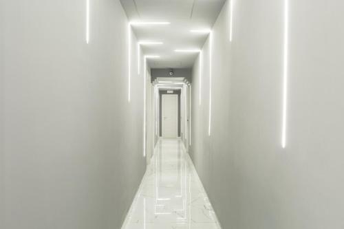 an empty corridor with white walls and a door at Hotel Bella Napoli in Naples