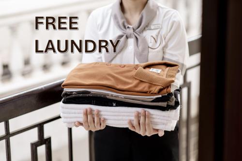 a woman is holding a stack of clothes at Lantern Hotel in Ho Chi Minh City