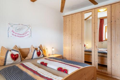 a bedroom with two beds and wooden cabinets at Thomasegg Hof Linde in Sarntal