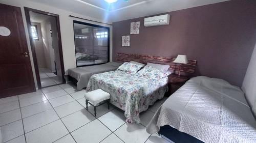a small bedroom with two beds and a window at Do Maraja in Búzios