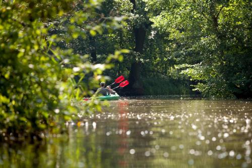un homme est en kayak sur une rivière dans l'établissement Ferienhaus 4 Prs, à Kaupen