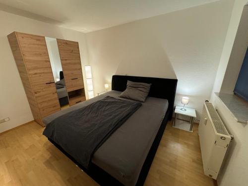 um quarto com uma cama grande e piso em madeira em Gemütliche 2 Zimmer Wohnung by Rabe - Netflix & Coffee-Bar em Karlsruhe