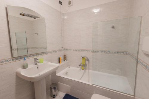 bagno bianco con lavandino e doccia di Casa Olga a Vallecrosia